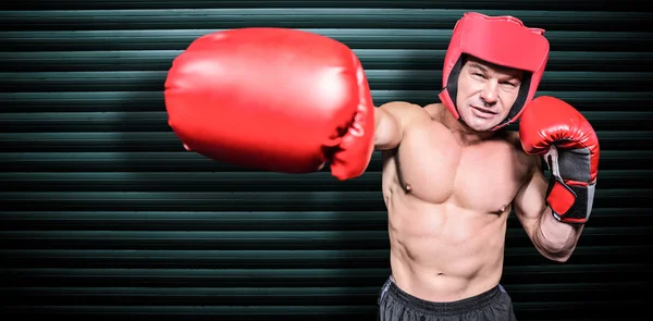 Boxer punching against black background — Stock Photo, Image