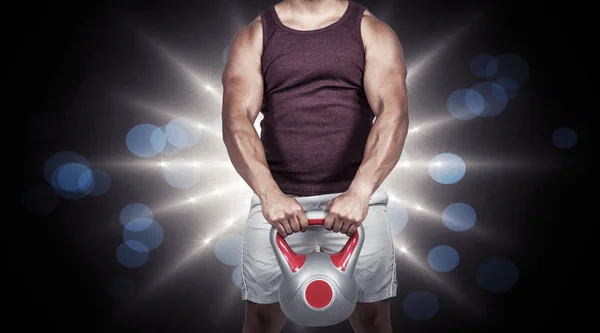 Muscular serious man holding a kettlebell — Stock Photo, Image