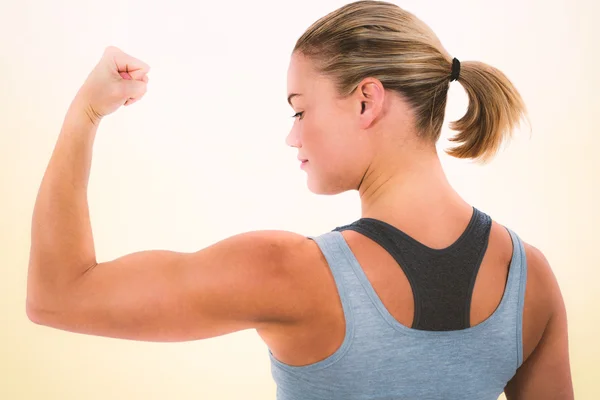 Vista posteriore della donna muscolare che flette i muscoli — Foto Stock