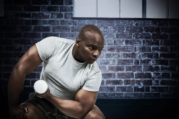 Composite image of fit man exercising with dumbbell — Stock Photo, Image