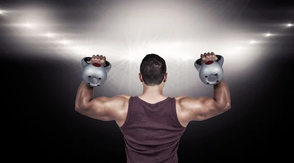 Zadní pohled na svalnatého muže, zvedání kettlebells — Stock fotografie