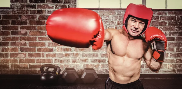 Boxer punching against black background — Stock Photo, Image