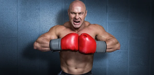 Boxer careca irritado com luvas de perfuração — Fotografia de Stock