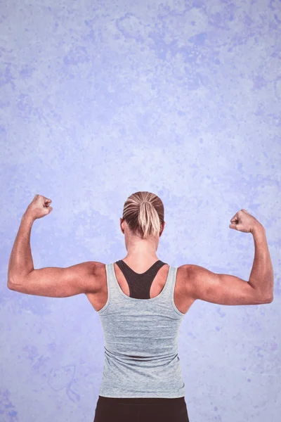 Vista posteriore della donna muscolare che flette i muscoli — Foto Stock