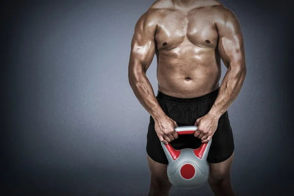 Muskulöser Mann, der schwere Kettlebell hebt — Stockfoto