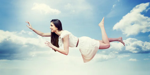 Chica en vestido blanco flotando en el aire — Foto de Stock