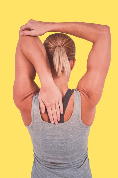Vista trasera de la mujer muscular estiramiento — Foto de Stock