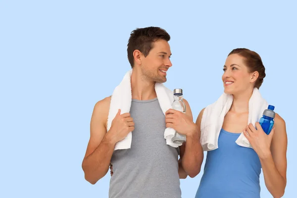 Happy fit young couple with water bottles — Stock Photo, Image