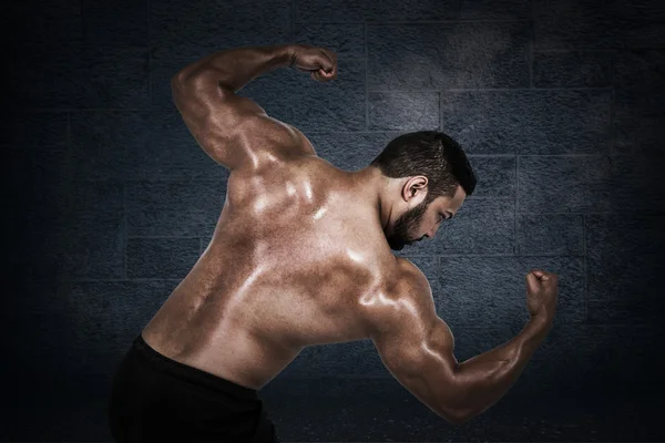 Homem muscular flexionando para câmera — Fotografia de Stock