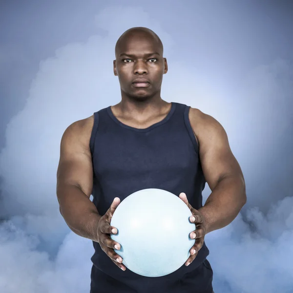 Мускулистый человек с весом мяча — стоковое фото