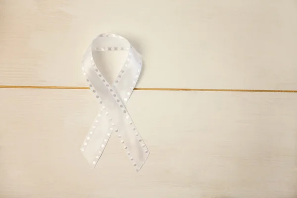 White ribbon on wooden desk — Stock Photo, Image