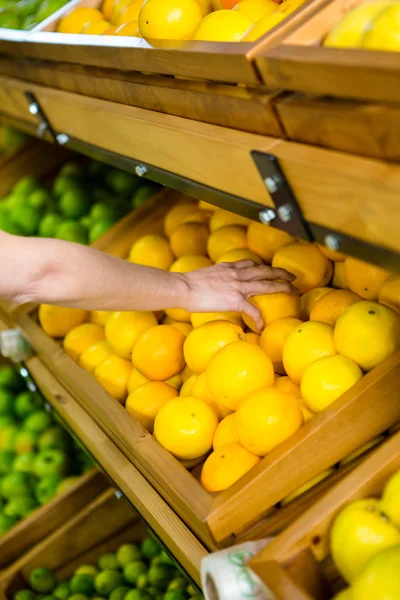 Vista de cerca de una mujer recogiendo naranja — Foto de Stock