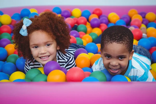 Lindos niños sonrientes en piscina de bolas de esponja — Foto de Stock