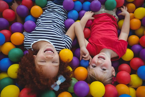 Schattige lachende meisjes in spons ballenbad — Stockfoto