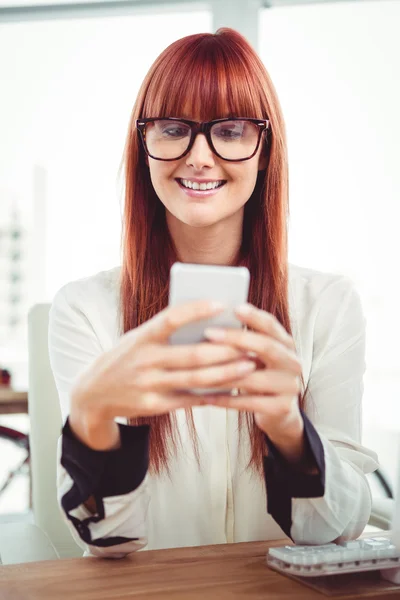 Una donna d'affari hipster sorridente che scrive sul suo smartphone — Foto Stock