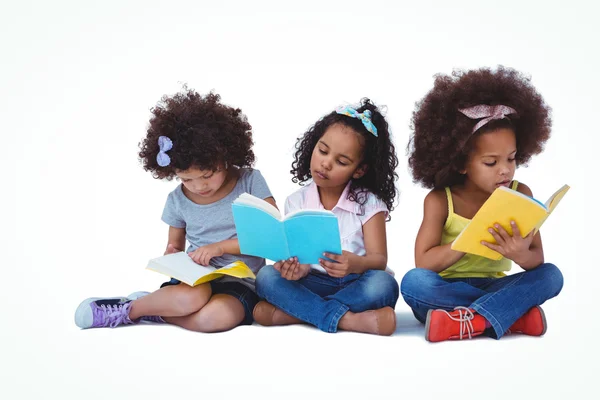 Милые девочки, сидящие на полу и читающие книги — стоковое фото