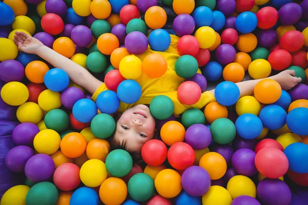 Lindo niño sonriente en la piscina de bolas de esponja —  Fotos de Stock