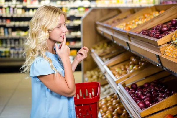 Mujer pensativa mirando cebollas —  Fotos de Stock