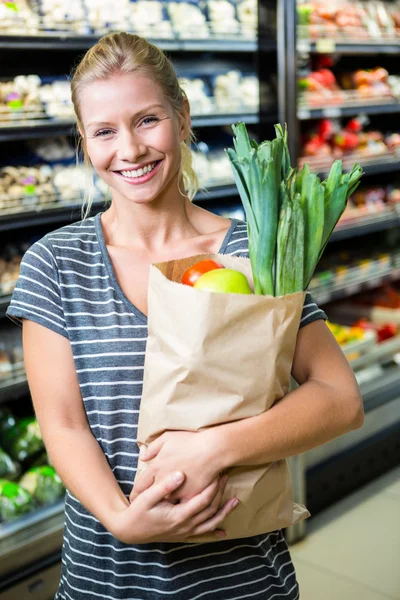 Красивая женщина, стоящая с пакетом продуктов — стоковое фото