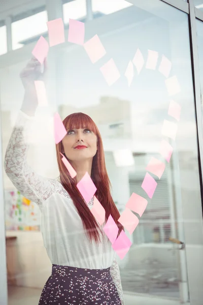 Smiling hipster woman doing a heart in post-it — Stock Photo, Image