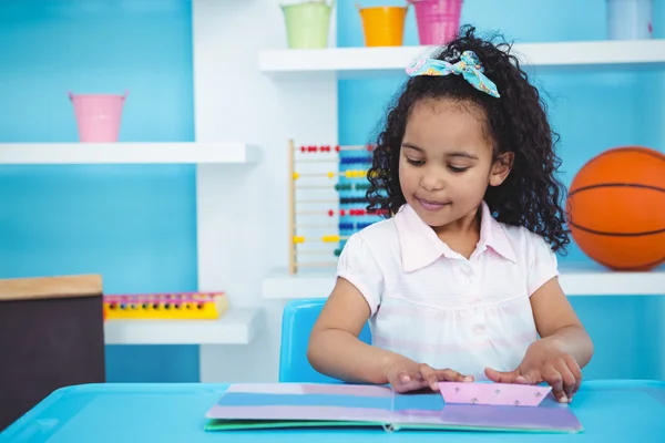 Menina bonito olhando para um livro — Fotografia de Stock