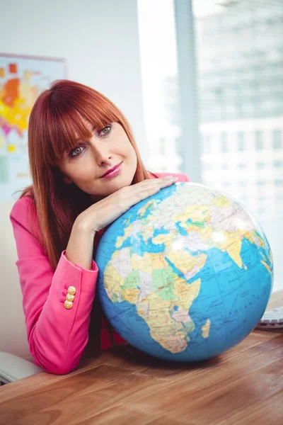 Hipster businesswoman lean on a globe — Stock Photo, Image