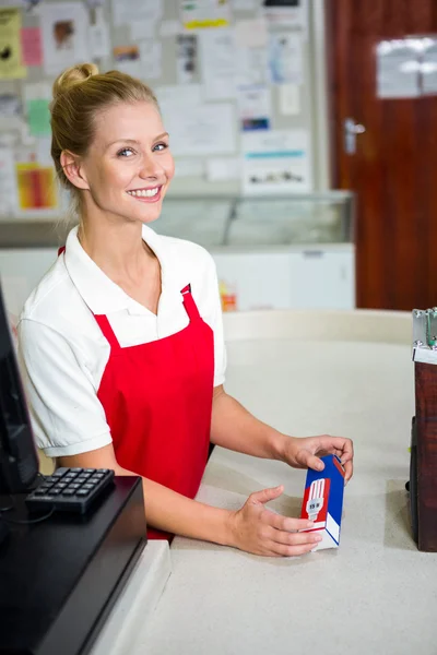 Lachende winkelbediende kijken naar product — Stockfoto