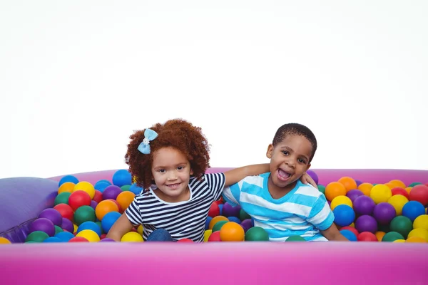 Lindos niños sonrientes en piscina de bolas de esponja — Foto de Stock