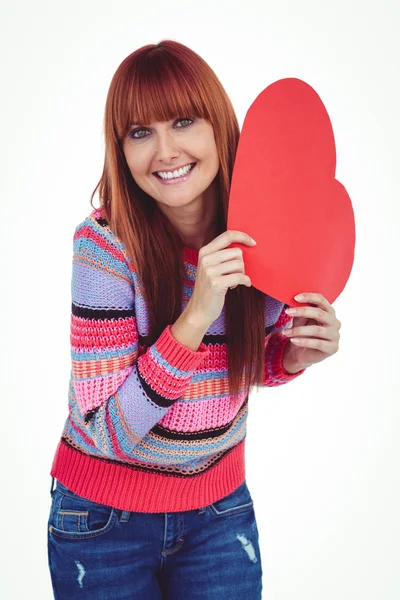 Smiling hipster woman holding a red heart — Stock Photo, Image