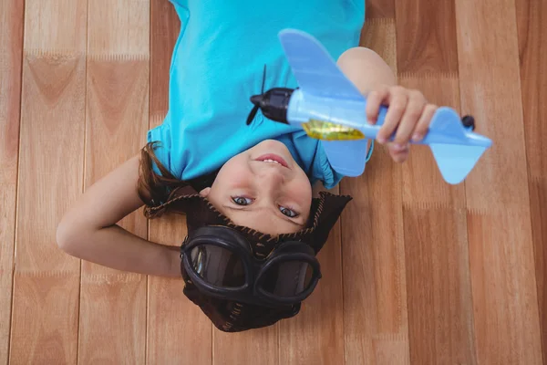 Lächelndes Mädchen spielt mit Spielzeugflugzeug — Stockfoto