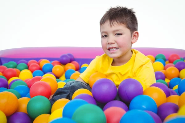 Lindo niño sonriente en la piscina de bolas de esponja — Foto de Stock