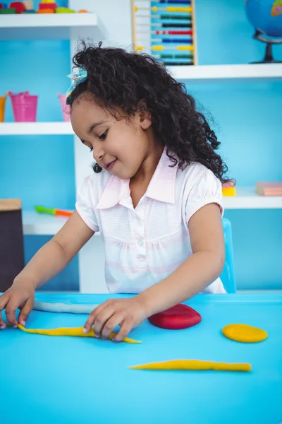 Cute girl playing with modeling clay — Stock Photo, Image