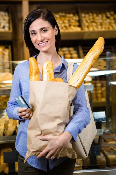 Mulher segurando pão e cartão de crédito — Fotografia de Stock