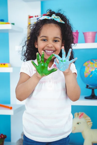 Menina bonito mostrando sua pintura coberto mãos — Fotografia de Stock