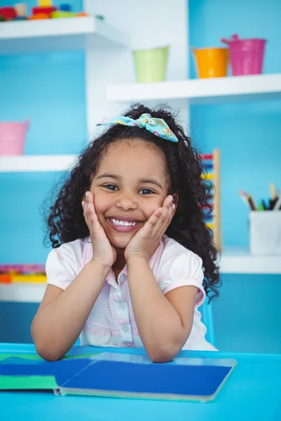 Jolie fille avec un livre souriant à la caméra — Photo