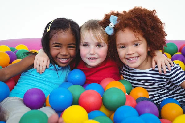 Cute smiling girls in sponge ball pool hugging — Stock Photo, Image