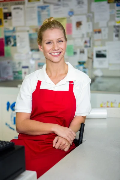 Sorrindo assistente de loja com braços cruzados — Fotografia de Stock