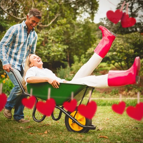 Pareja feliz jugando con una carretilla — Foto de Stock