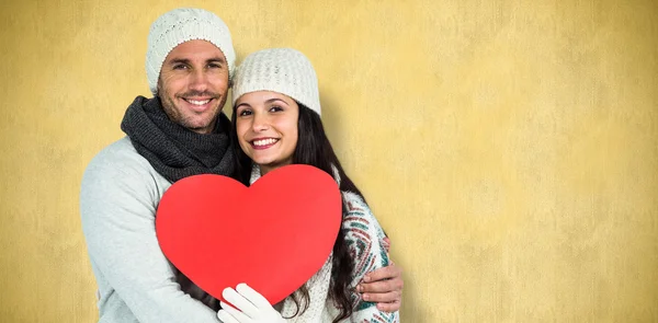Smiling couple holding paper heart — Stock Photo, Image