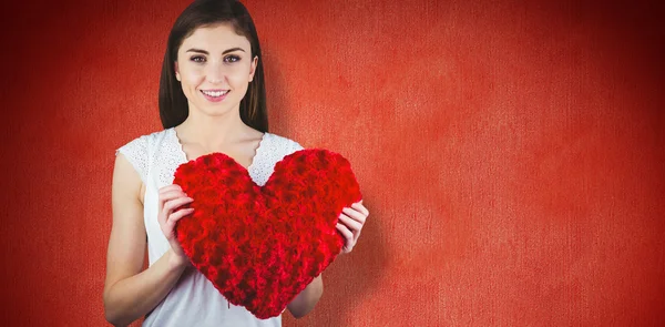 Mujer sosteniendo cojín de forma de corazón — Foto de Stock