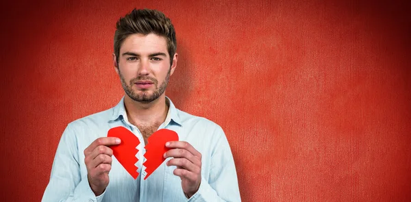 Sad man holding heart halves — Stock Photo, Image