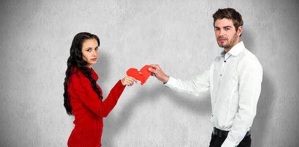 Retrato de pareja sosteniendo el corazón roto rojo — Foto de Stock