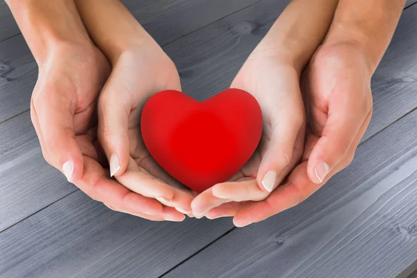 Couple holding miniature heart in hands — Stock Photo, Image