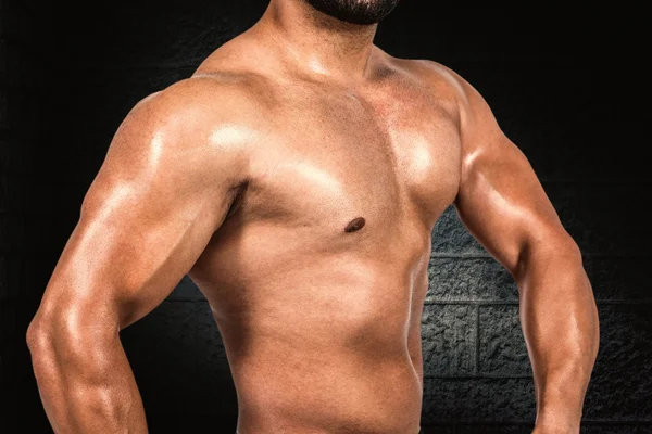 Svalnatý muž protahuje jeho biceps — Stock fotografie