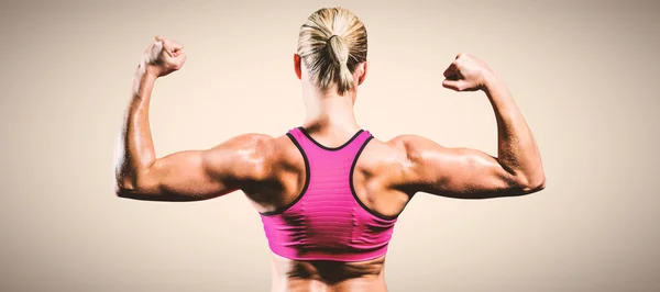 Muskulöse Frau, die ihre Arme beugt — Stockfoto