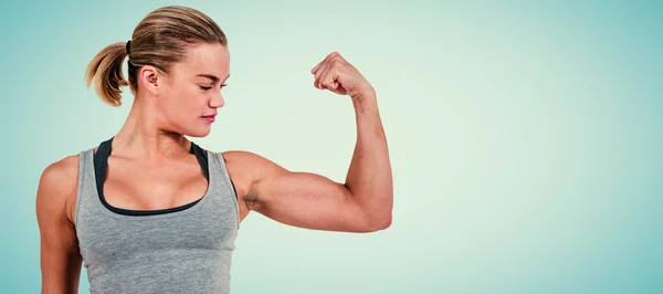 Serious muscular woman flexing muscle — Stock Photo, Image