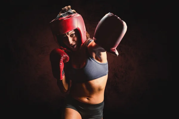 Boxeador feminino com luvas e punchin headgear — Fotografia de Stock