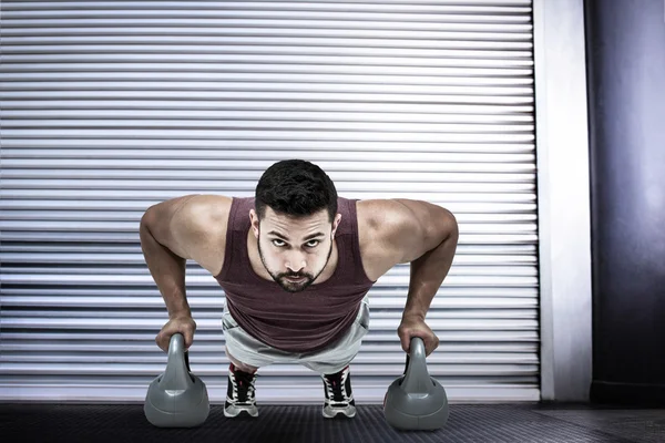 Muskulös man göra push ups med kettlebells — Stockfoto
