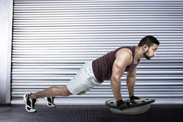Homem muscular fazendo bosu push ups — Fotografia de Stock