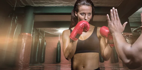 Boxeadora femenina con postura de lucha contra la mano del entrenador — Foto de Stock